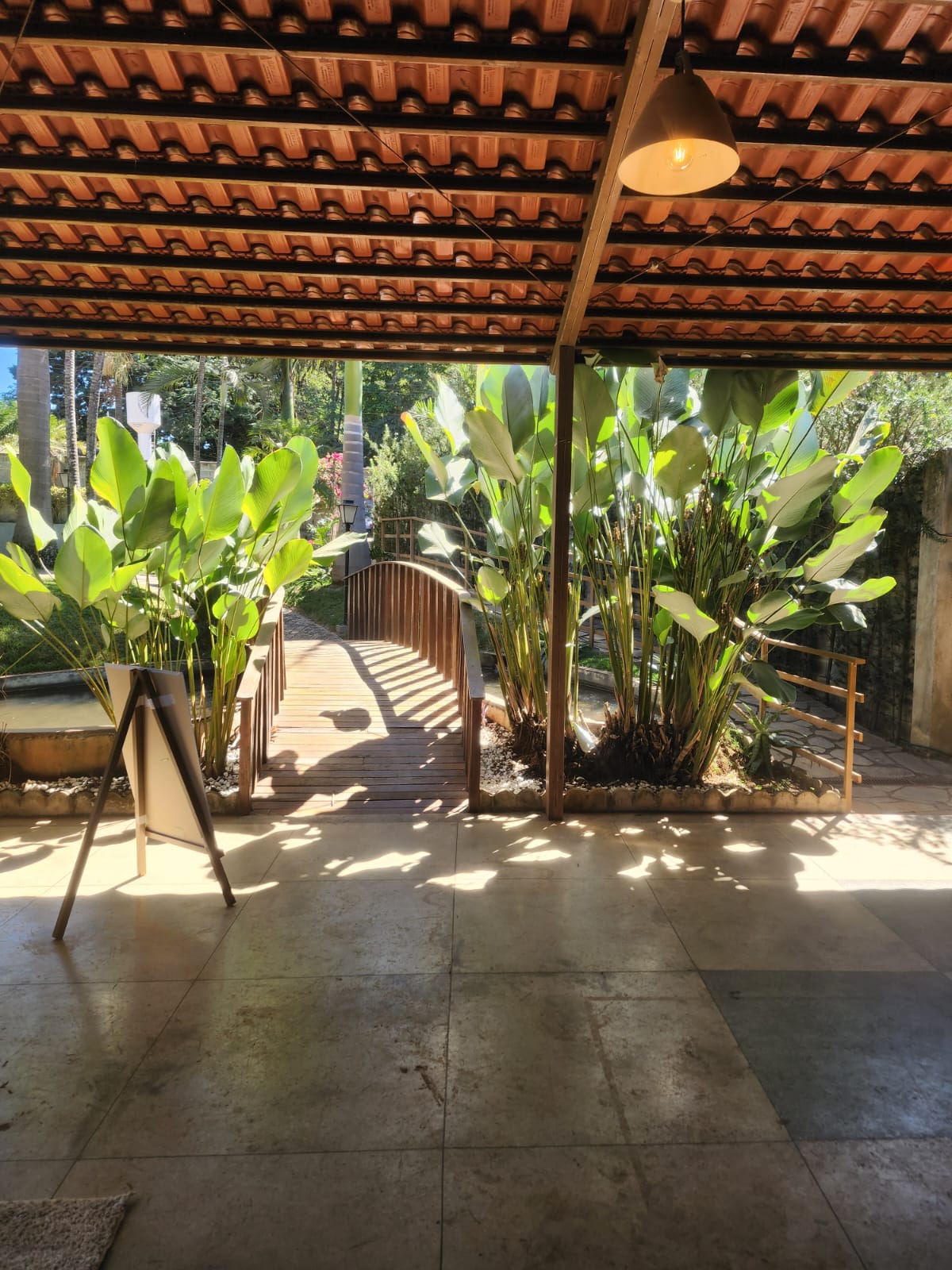 Varanda coberta com vista para a ponte e o jardim
